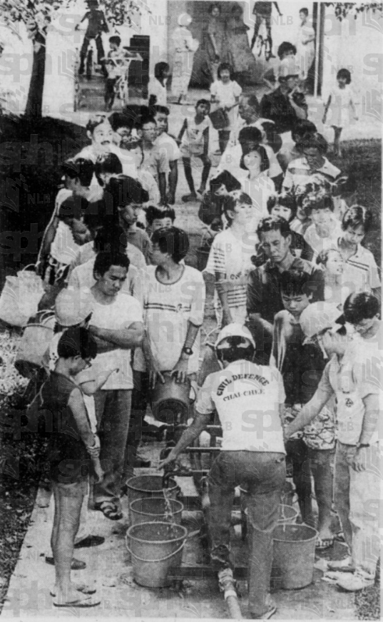 Residents collecting water in buckets from public taps.